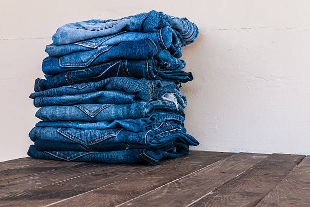 istock stack of various shades of blue jeans on old wood 501648940