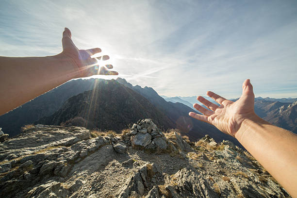 istock Woman's arms stretch towards sun setting over mountains 501649584