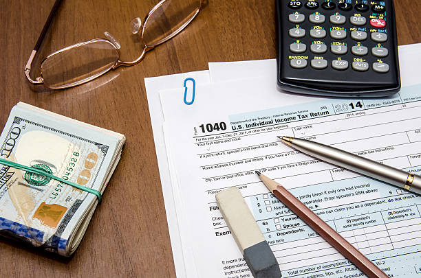 istock tax form 1040 with glasses, pen and dollar 501649628