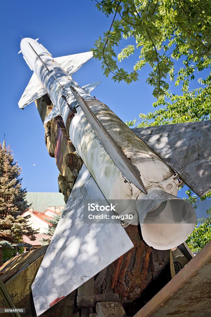 Old missile, but still danger Soviet S-75 Dvina - high-altitude, command guided, surface-to-air missile against blue sky camouflaged in the leaves Aiming Stock Photo