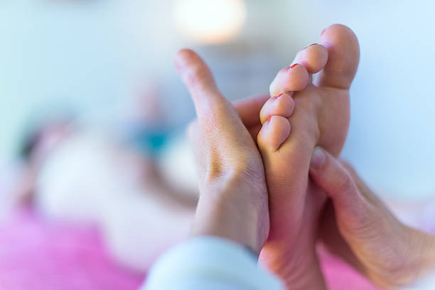 terapeuta mãos massageando o pé feminino - reflexology human foot foot massage therapy - fotografias e filmes do acervo