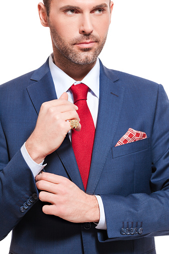 Portrait of elegant businessman wearing suit. Standing against white background. Close up of torso and hands.