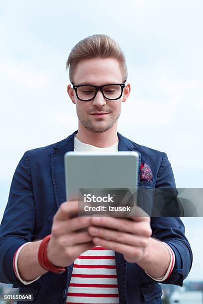 Blonde Young Man Using A Digital Tablet Outside Stock Photo - Download Image Now - Digital Tablet, Happiness, Luxury