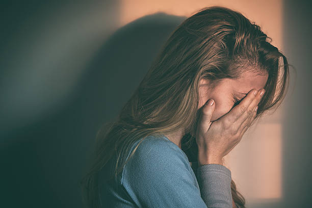 mujer sentada solo y deprimido - mental abuse fotografías e imágenes de stock