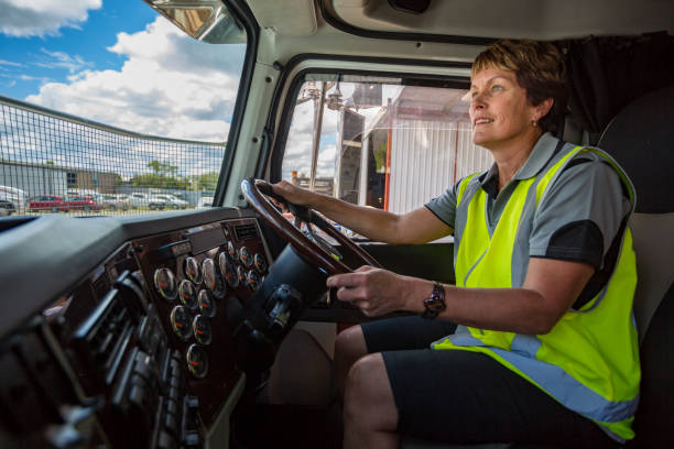 Happy Woman Driving a Truck Wearing Hi-Vis Clothes stock photo