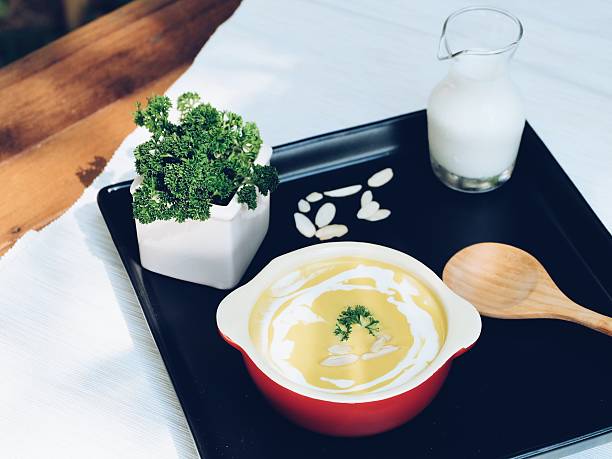 Homemade Pumpkin Soup topping with cream, almond slice and parsley