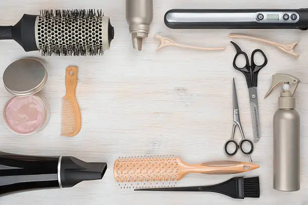 Photo of Hairdressing tools on wooden background with copyspace in the middle