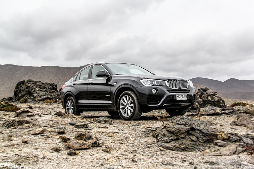 Atacama, Chile - November 14, 2015: New black crossover BMW F26 X4 is parked at the stone desert.