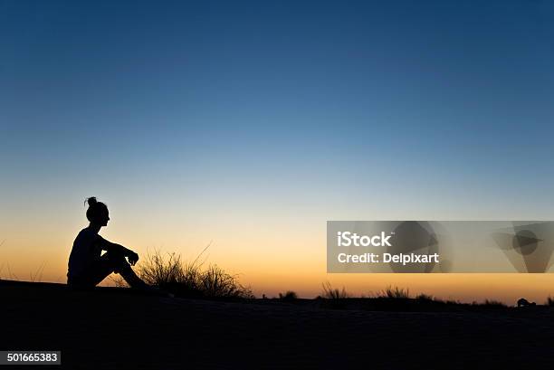 Silhouette Einer Frau Sitzt In Den Sonnenuntergang Stockfoto und mehr Bilder von Anfang - Anfang, Betrachtung, Blau