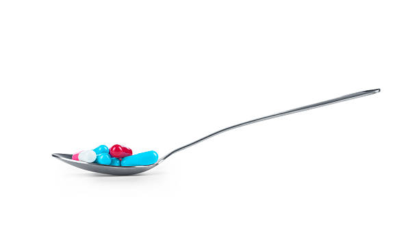 istock Spoon full of pills on a white background 501665748