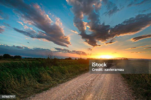 Hermosa Puesta De Sol En Una Carretera De Campo Foto de stock y más banco de imágenes de Puesta de sol - Puesta de sol, Carretera de tierra, Camino