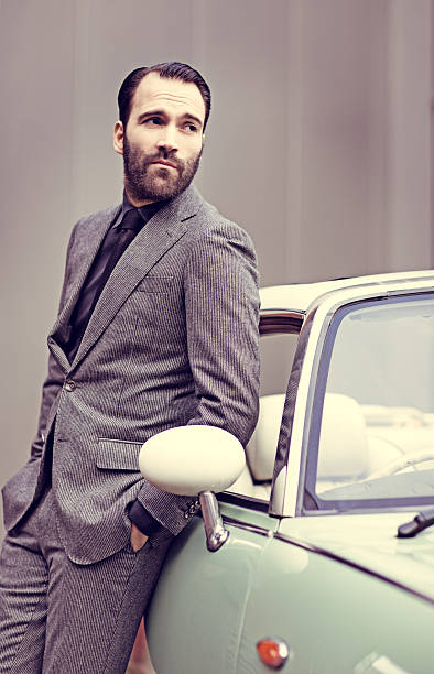 istock Stylish retro dressed man standing next to vintage car 501667970