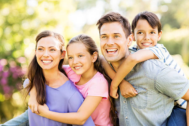 istock Cheerful Parents Piggybacking Children In Park 501668401