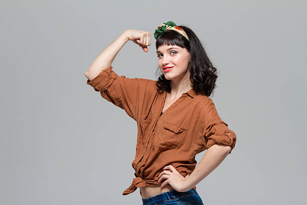 Beautiful positive happy young woman showing biceps stock photo