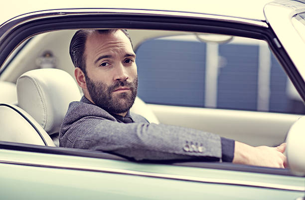 istock Stylish retro dressed man driving vintage car 501668500