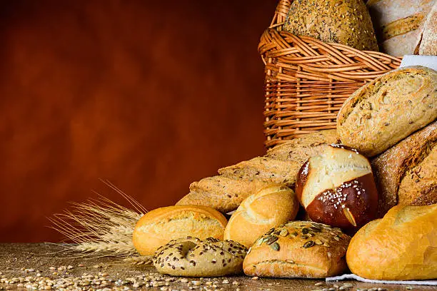 bread basket and bun in traditional still-life on wood table with grain and wheat and flour