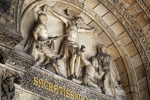 Paris, France - July 23, 2015: The bas relief depiction of the crucifixtion of Christ above the main entrance to the Sacré-Cœur Basilica, the iconic church that dominates the Parisian skyline from the highest hill in Paris.