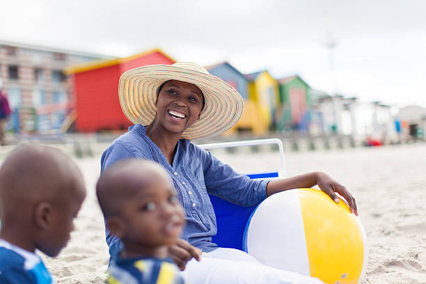 istock African mother sitting with her sons on the beach 501670761