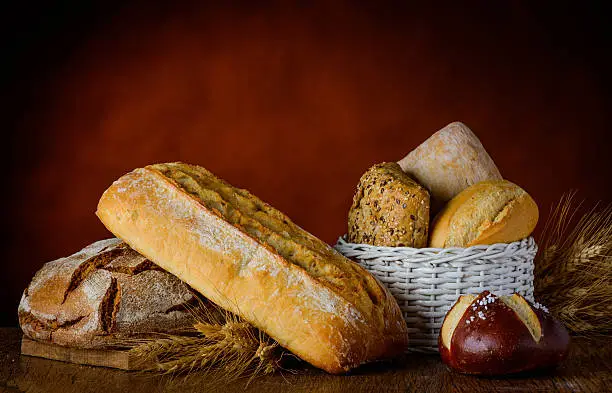 bread in traditional still life with bun basket  and wheat.