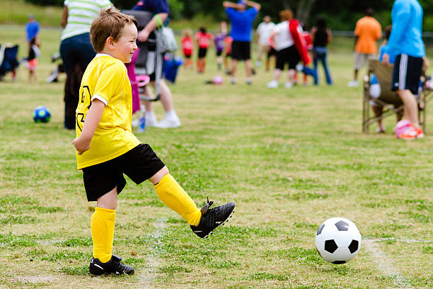 istock Young child boy playing soccer during organized game 501671815