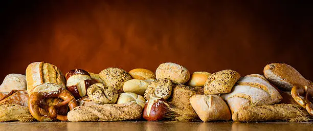 a pile of bun and bread on a wooden table in traditional still-life