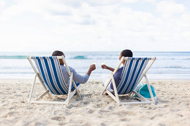 istock African couple drinking champagne on the beach 501672339