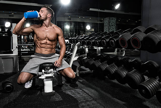 Man in the gym drinking protein shake drink stock photo