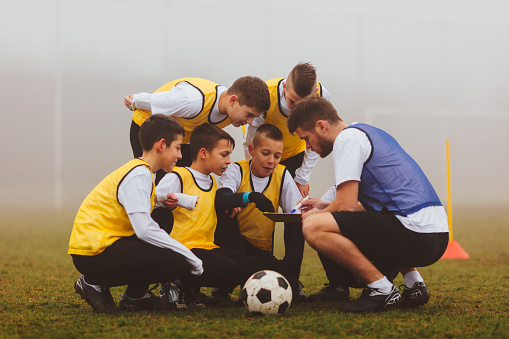 Entrenador dar instrucciones a su equipo de fútbol de niños. photo