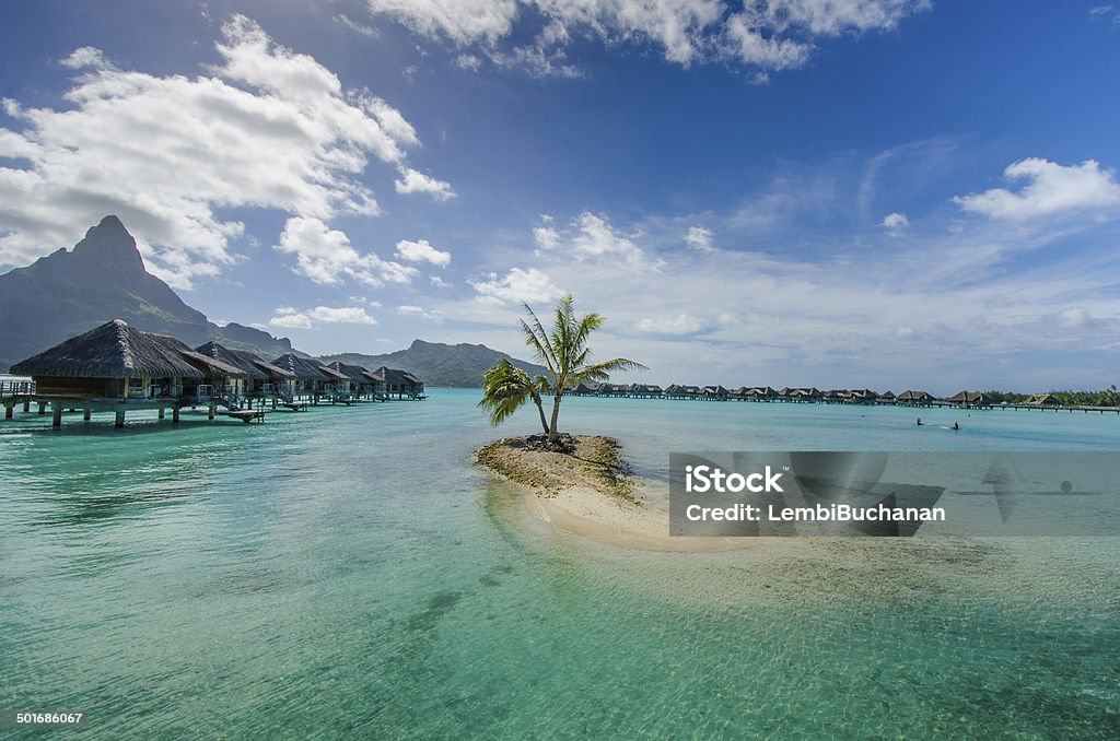 Overwater bungalows in Pacific Luxury overwater bungalows with view of amazing blue and turquoise colors of the lagoon and Bora Bora in the distance. Bora Bora Stock Photo
