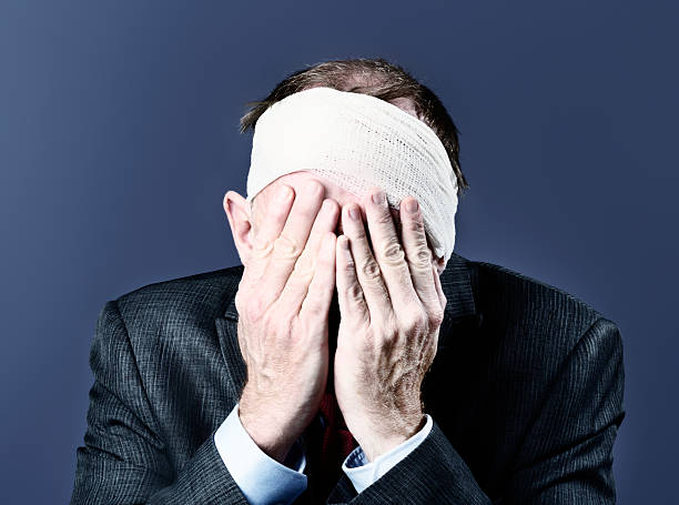 istock Man with bandaged head covers face with his hands 501691405