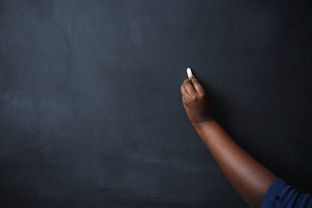 afrikanische frau hand zeichnen auf tafel - blackboard writing chalk teacher stock-fotos und bilder
