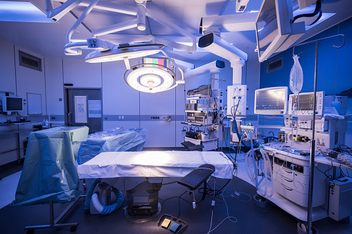 Operating theater with light shining on empty bed. Preparation, absence, organisation, medical equipment.