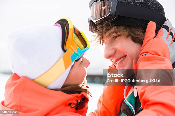 Young Adults Skiing And Snowboarding Snow Play In Winter Stock Photo - Download Image Now