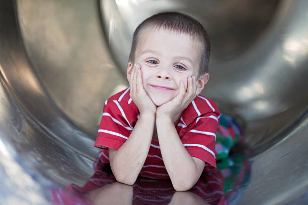 istock Cute boy, sliding down the slide, smiling 501710387
