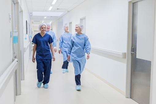 Equipo quirúrgico caminar por la zona de hospital, vista de frente photo