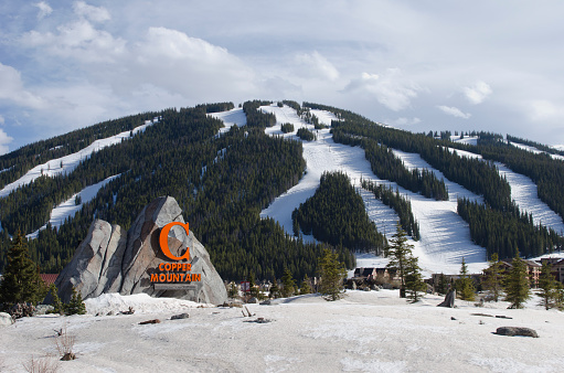 Copper Mountain, United States - May 3, 2014: Copper Mountain Ski Resort - The ski resort at Copper Mountain has grown over the years.  Pictured here is the entrance with new sign and snow covered ski runs in the background.