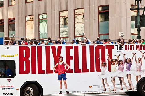 New York, USA - July 11, 2010: tourists in an upperdecker city sights bus in New York, USA.  ADs on the bus for  Broadway production Billy Elliot opened at the Imperial Theatre 1. Oct 2008.