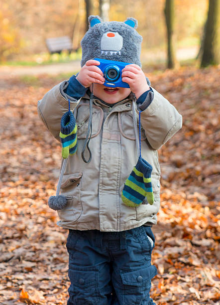 istock Boy taking a picture in autumn park 501714320