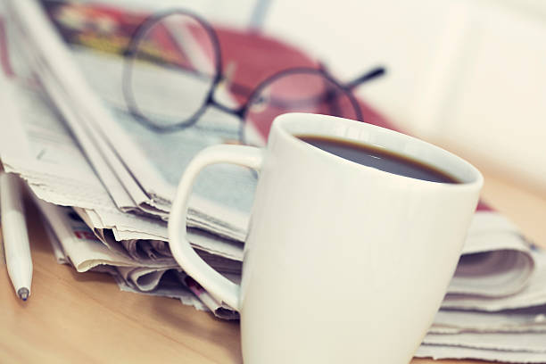 istock Cup of coffee and newspaper on table 501717512