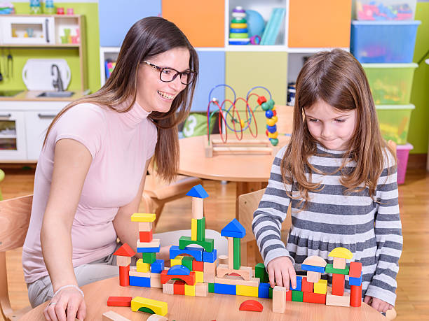 istock Kindergarten teacher with shy cute girl 501717892