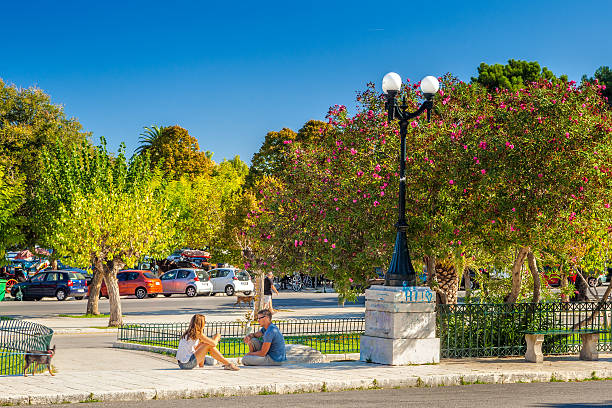 Locals and tourists at Platia Leonida Vlachou park Kerkyra, Corfu, Greece - September 24, 2013:: Famous cafes at building at Kapodistriou street with lot of tourists. This street located near platia Enoseos at old city. corfu holiday palace stock pictures, royalty-free photos & images