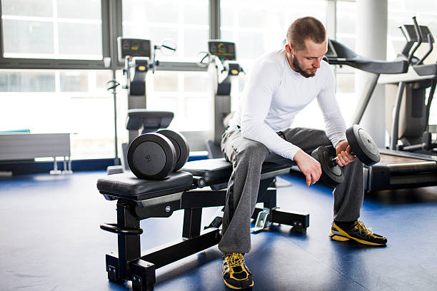 istock Young man in a gym - dumbbells 501733847