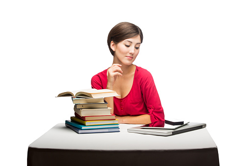 Books, coffee and lamp rotating on desk in library, book shelves in dark room