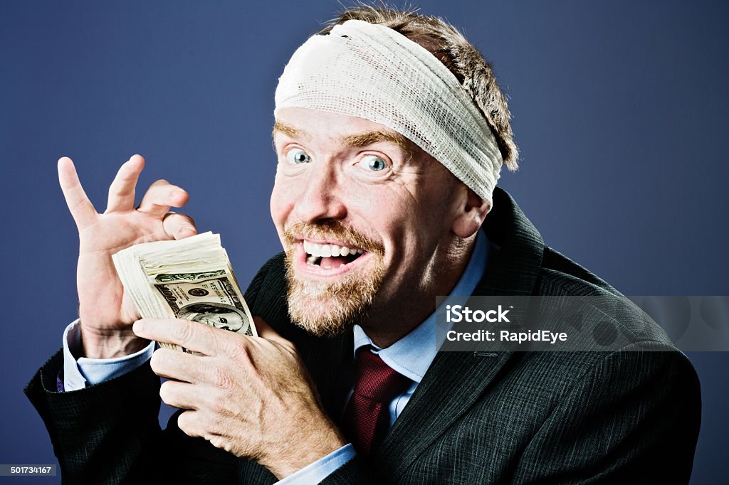 Bandaged businessman counts money gleefully, compensation perhaps? NOTE TO INSPECTOR: The banknotes have been digitally distorted to prevent unawlful reproduction. 50-59 Years Stock Photo