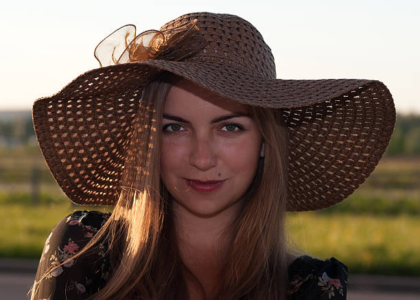 девочка в коричневая плетеной шляпе на фоне поля - affectionate desire beauty brown стоковые фото и изображения