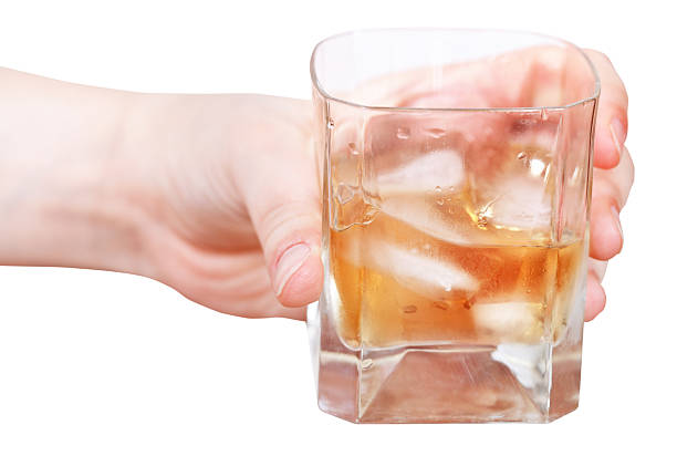 istock hand holds whiskey on ice in glass isolated 501735859