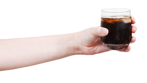istock hand holds soft drink with ice in glass 501735865