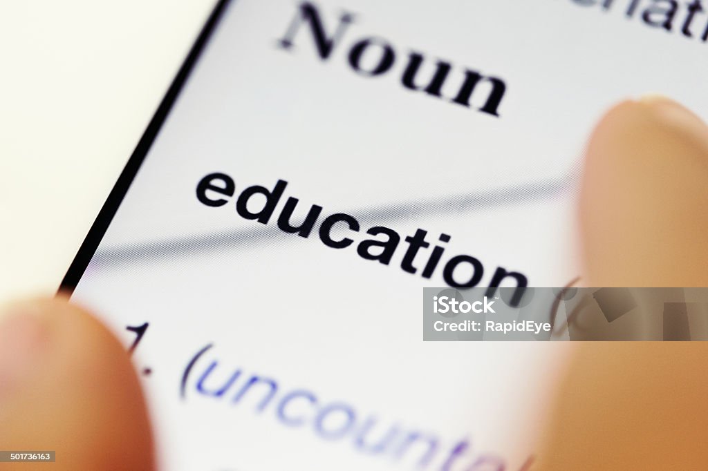 "Education" definition in online dictionary Fingers rest on the "Education" listing from an online dictionary, displayed on a digital tablet. Business Stock Photo