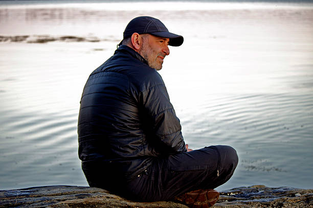 istock Man Sitting Alone by the Ocean 501736911
