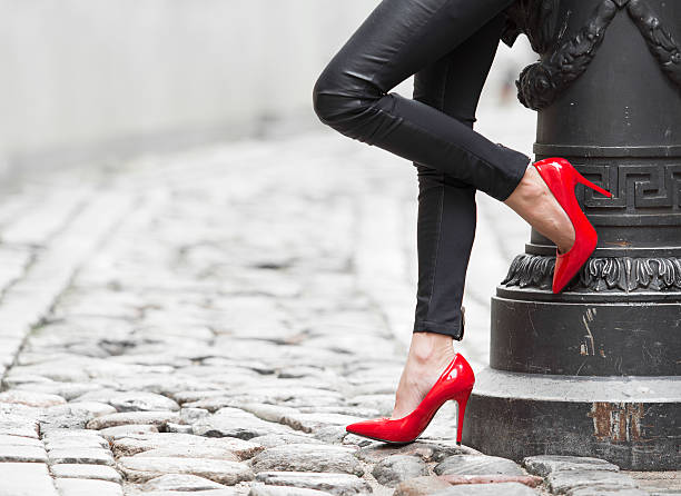 女性、ブラックのレザーパンツに合わせるとレッドのヒールの靴 - human leg high heels sensuality women ストックフォトと画像